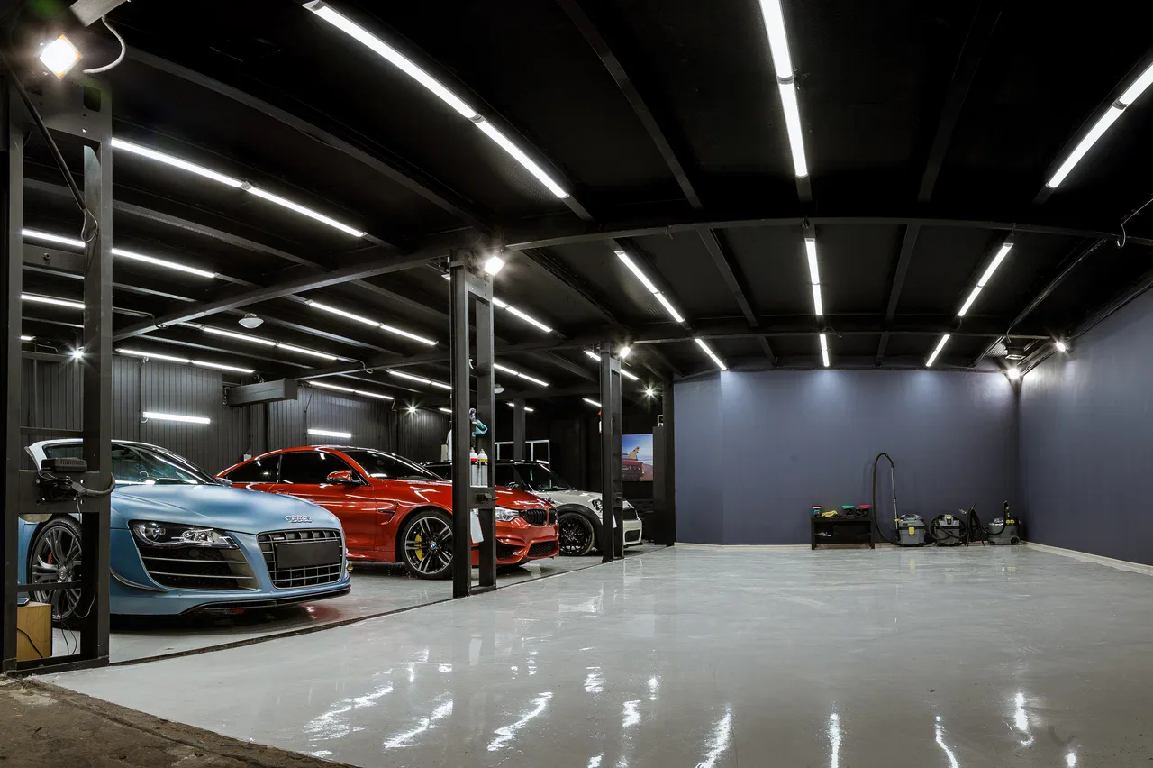 Multiple performance cars arranged inside a spacious detailing studio